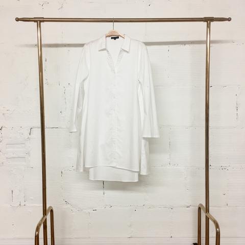 White dress shirt hanging on to a gold rack