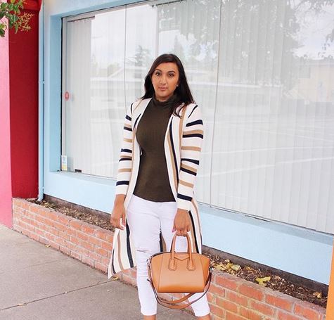 woman wearing a stripe long jacket with brown top and white pants