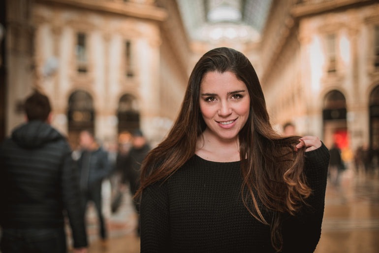 a woman in a black dress standing in a city