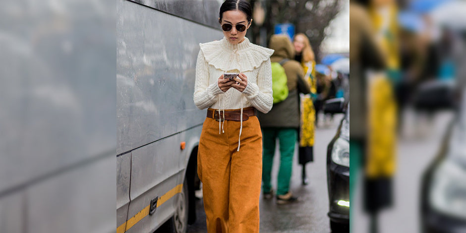 a woman in a yellow jacket standing next to a bus