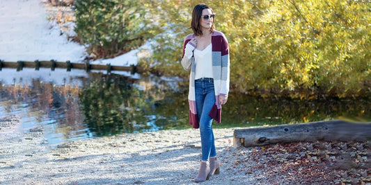 a woman standing on a beach next to a body of water
