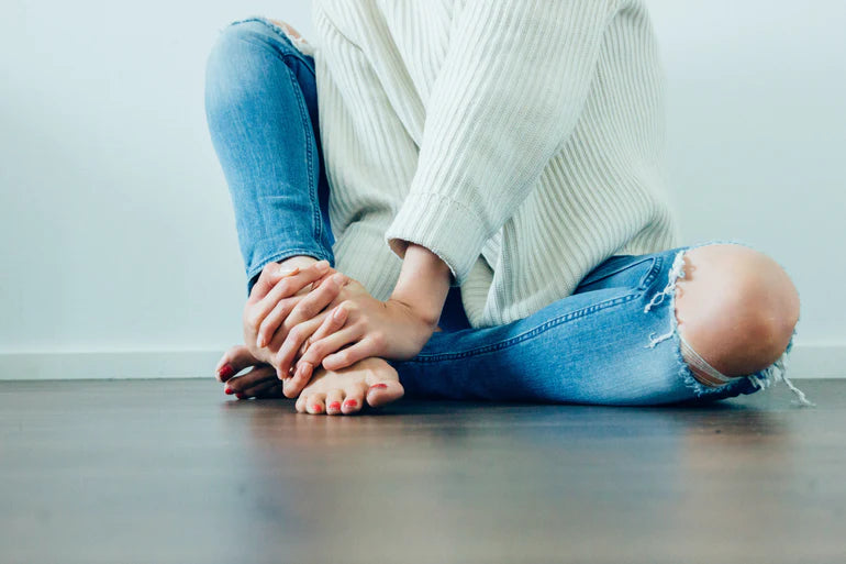 there is a woman sitting on the floor with her feet crossed