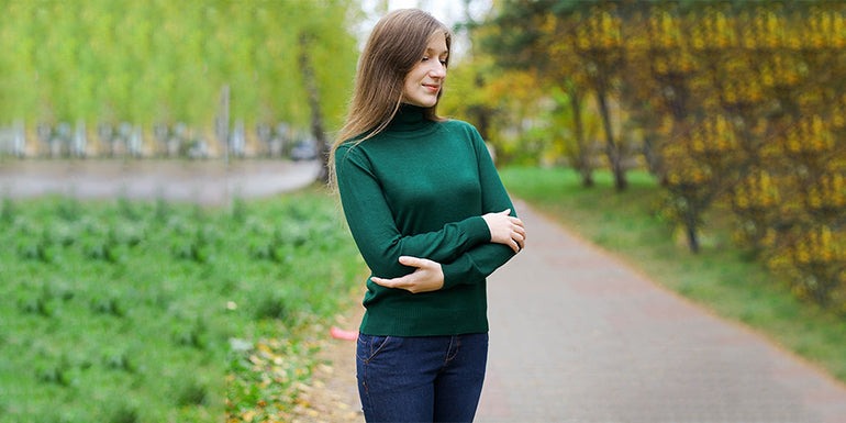 there is a woman standing on a path with her arms crossed