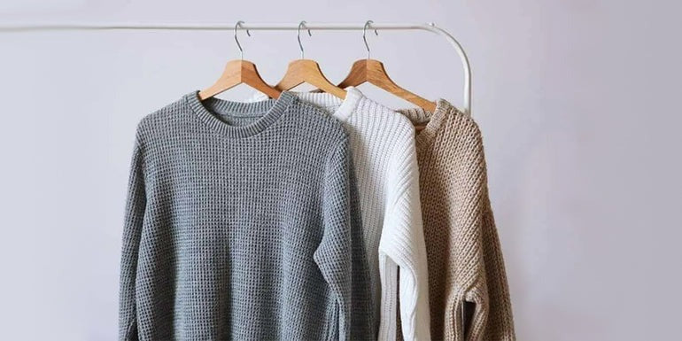 three sweaters on hanger of diffrent colors