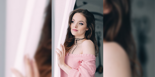women looking outside the window wearing pink dress