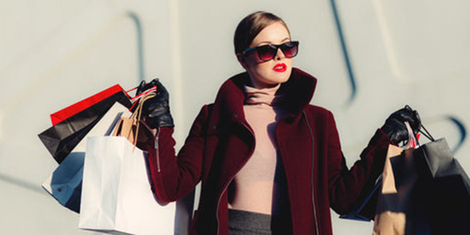 women with sun glasses and purple jacket returning from shopping